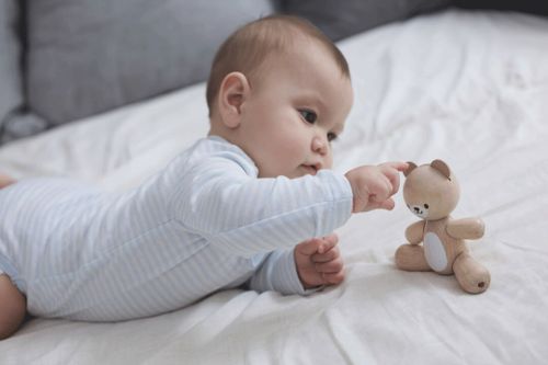 תינוק בזמן בטן חוקר דמות דובי מעץ של PlanToys עם גפיים זזות