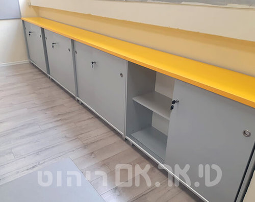 ארונית נמוכה עם פלטה צהובה לשמירת קלסרים