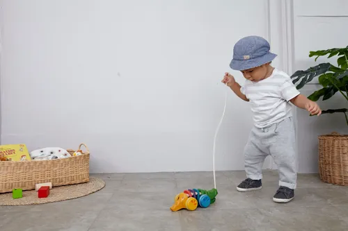 מעוט משחק וגורר תנין נגרר מעץ של PlanToys בצבעי הקשת לעידוד הליכה וזיהוי צבעים