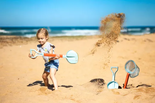 ילד/ה נהנה/ית ממשחק 2 ב-1 של CompacToys בים, משלב/ת חפירה ודיג