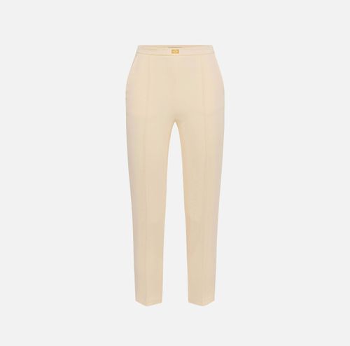 Trousers in crêpe fabric with pockets and logo plaque