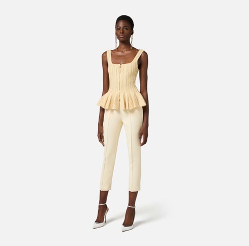 Trousers in crêpe fabric with pockets and logo plaque
