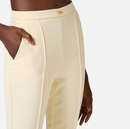 Trousers in crêpe fabric with pockets and logo plaque