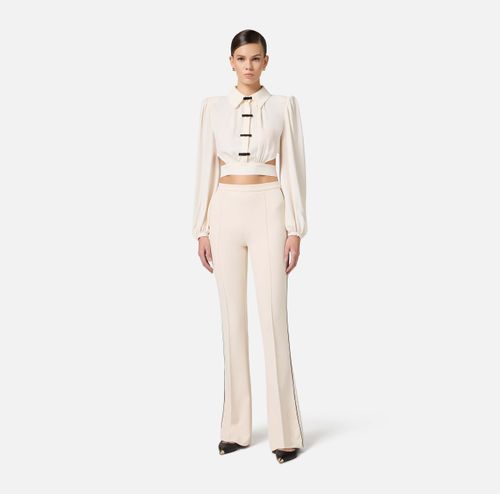 Trousers in crêpe fabric with contrasting piping