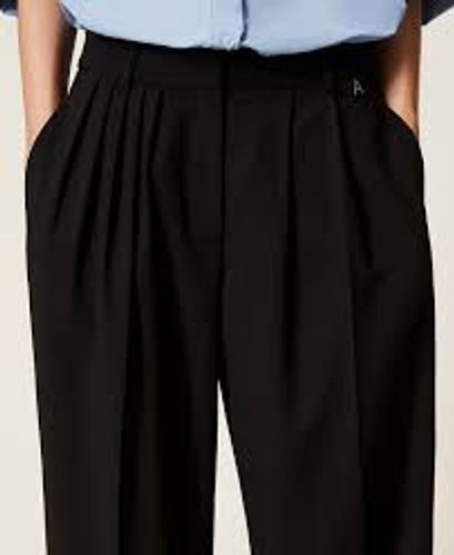 Trousers with asymmetrical pleats