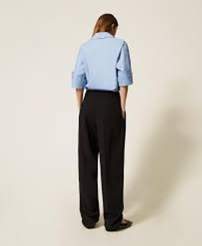 Trousers with asymmetrical pleats