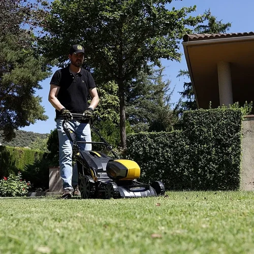 אדם מפעיל את המכסחת דשא נטענת גרלנד Apache KEEPER 40V 395S-V23 גוף בלבד בגינה