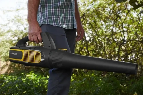מפוח עלים חשמלי נטען STIGA BL700e בפעולה בגינה ירוקה – ביצועים גבוהים ושקט מרשים.