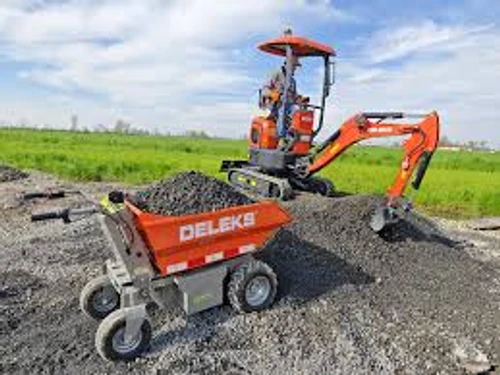 מריצה חשמלית מקצועית DELEKS XE500HE בשטח עבודה עם מיני מחפר להעברת חצץ ואדמה