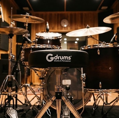 כסא תופים מקצועי Gdrums GD-HDT300 - מושב עגול שחור מרופד בקטיפה עם לוגו Gdrums לבן מודפס, חצובה כפולה כרום מבריק עם 3 רגליים ורגליות גומי שחורות, מנגנון הידראולי להתאמת גובה, עיצוב מקצועי ויציב