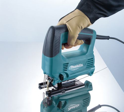 יד אוחזת מסור אנכי 450W חשמלי דגם M4301B תוצרת MAKITA בזמן עבודה