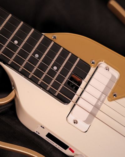 גיטרה חשמלית Donner HUSH X PRO בצבע White Luxe לבן headless עם מערכת אפקטים מובנית מסך OLED פיקאפים Alnico USB-C Bluetooth