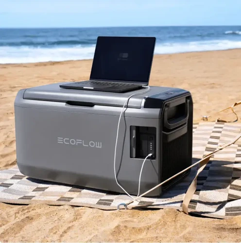מקרר נייד לרכב EcoFlow Glacier 45L על חוף הים עם מחשב נייד מחובר לטעינה, שימוש בקמפינג ובשטח