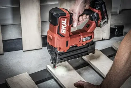 אקדח מסמרים נטען SKIL 18V בשימוש לחיבור לוחות עץ במסגרת עץ, כלי עבודה אדום מקצועי לעבודה בנגרות ובבנייה