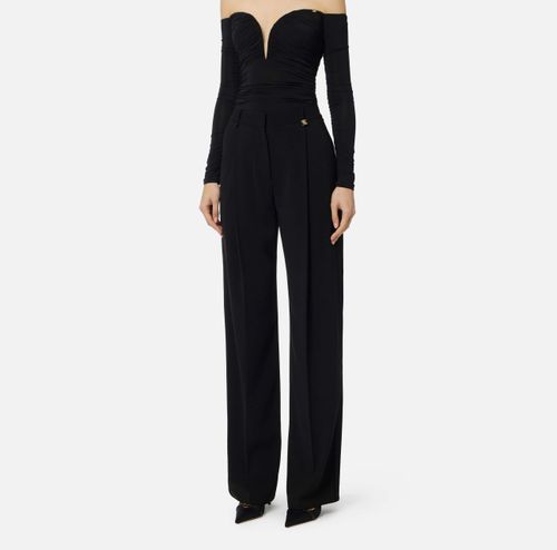 Trousers in lightweight crêpe fabric with logo charm