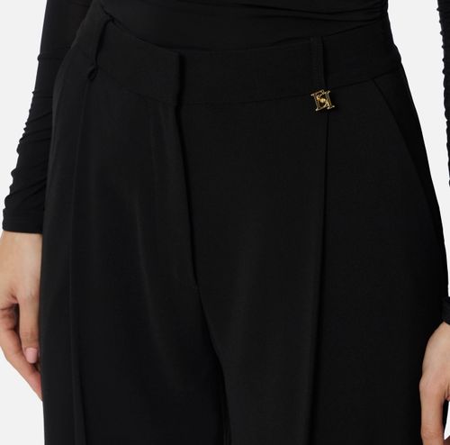 Trousers in lightweight crêpe fabric with logo charm
