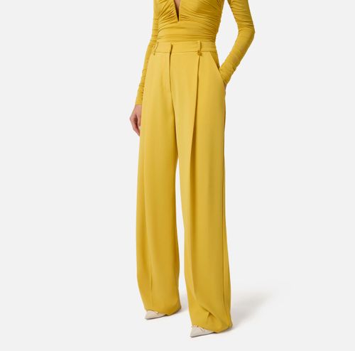 Trousers in lightweight crêpe fabric with logo charm