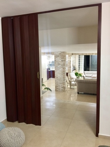 מחיצת הרמוניקה מתקפלת בגוון מהגוני בבית פרטי לכניסה לסלון