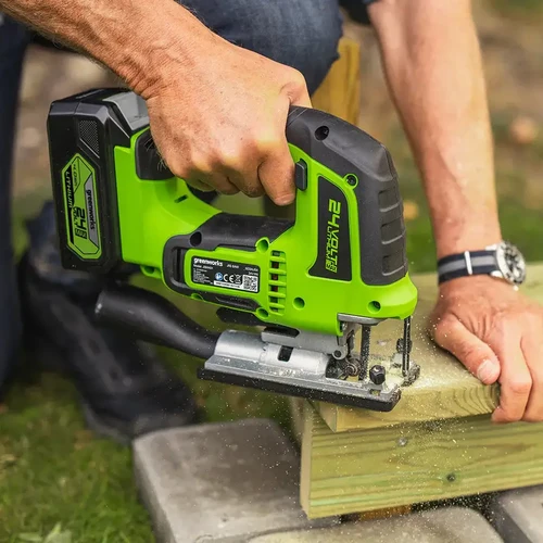 מסור אנכי נטען Greenworks 24V בזמן חיתוך קורת עץ, עם מנוע Brushless, סוללת ליתיום 24V ועבודה נקייה ומדויקת בשטח