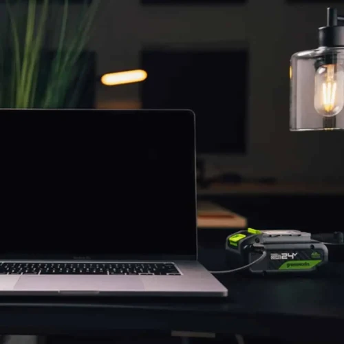 סוללת Greenworks POWERALL 24V 6Ah עם יציאת USB-C דו-כיוונית מחוברת למחשב נייד ומשמשת כפאוור בנק עוצמתי לטעינה ניידת בכל מקום.