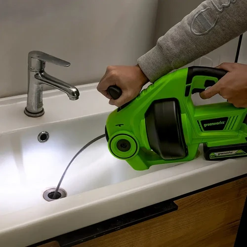 מכונת פתיחת סתימות Greenworks נטענת 24V בפעולה בכיור, לניקוי מהיר של צנרת וניקוזים בבית.