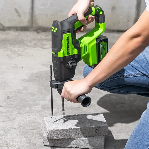 שימוש בפטישון נטען Greenworks GD24SDS2 לקידוח בבטון עם ידית אחיזה צדדית ליציבות ושליטה מרבית בעבודה