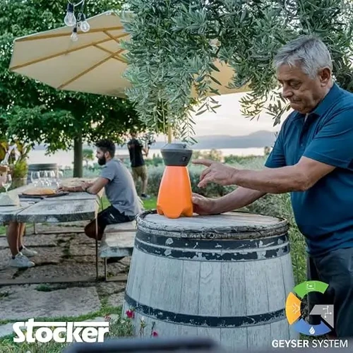 מרחיק חרקים מעופפים STOCKER GEYSER Mini 2L בפעולה בגינה, מערכת ערפול אוטומטית להרחקת יתושים ומעופפים לשימוש ביתי.