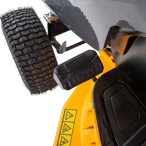 תקריב על דוושת הבלם השחורה עם הכיתוב BRAKE והצמיג הקדמי בעל האחיזה המשופרת של טרקטורון כיסוח Cub Cadet LT2 R92