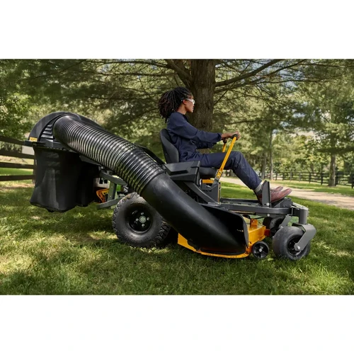 מפעילה נוהגת בטרקטורון כיסוח מקצועי Cub Cadet ULTIMA Z3-60 המצויד במערכת צינור וסל איסוף דשא אחורי גדול בשטח