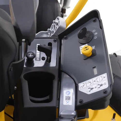 תקריב על פאנל הבקרה של טרקטורון הכיסוח Cub Cadet ULTIMA Z3 60, המציג את מתג ההתנעה עם מפתח, כפתור בטיחות צהוב, מחזיק כוסות ומדבקות הוראות הפעלה