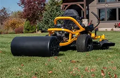 רולר לדשא Agri-Fab 45-0606 מחובר לטרקטורון כיסוח במהלך יישור מדשאה