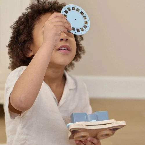 תמונה של ילד מביט ישירות על דסקית עם שקופיות - מקרן סיפורים מעץ שועל - Little Dutch