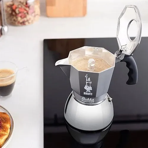 מקינטת Bialetti Brikka Induction אפור במטבח ביתי לצד כוס אספרסו