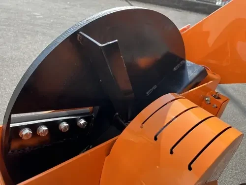 תקריב מערכת הריסוק של מרסקת ענפים DELEKS DK900, המציג את דיסק החיתוך, הסכינים ומגן המנגנון הכתום