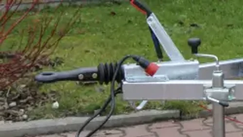 תקריב יצול הגרירה של מרסקת גזם נגררת LASKI LS 160 PB, כולל ראש חיבור לרכב גורר, ידית בלם וצנרת חשמל לנגרר