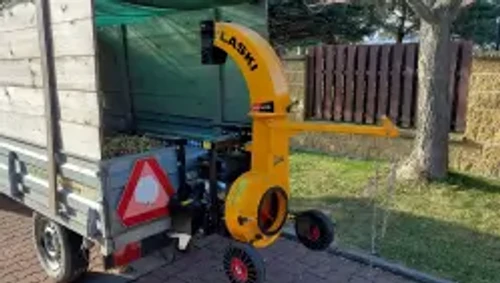 שואב עלים תעשייתי LASKI VD 405 – המכונה מוצבת לצד נגרר לאיסוף עלים, עם ארובת פליטה גבוהה ומנוע בנזין Kohler