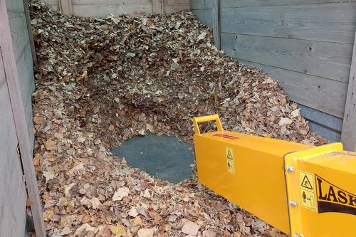 שואב עלים תעשייתי LASKI VL 300 – ארובת פליטה צהובה המכוונת את העלים הנשאבּים לתוך נגרר איסוף גדול מלא בעלים יבשים
