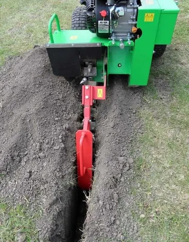 טרנצר LASKI TR50/6.5 במהלך חפירת תעלה צרה בקרקע מדושאת, מבט מאחור המציג את מנגנון החפירה, פינוי האדמה לצד התעלה ועבודת המכונה להנחת תשתיות