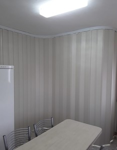 מחיצה מתקפלת על מסילה מתעגלת בגוון קרם לחלוקה בבית פרטי 