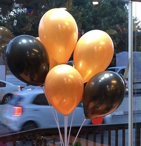 מעמד לבלוני אוויר עם בלונים בצבעים כתום ושחור