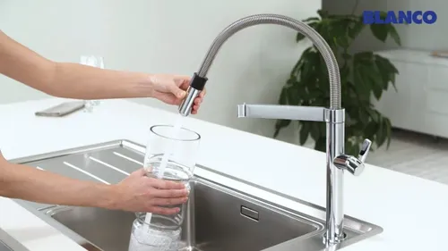 ברז מטבח BLANCO קולינה כרום 517597 מותקן על שיש במטבח מודרני, עם קפיץ תעשייתי בולט.