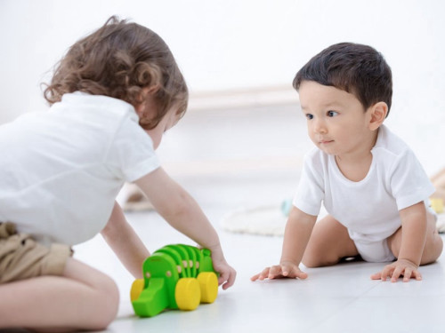 פעוטות משחקים עם תנין נגרר מעץ של PlanToys (הדגם הקלאסי הירוק) לעידוד הליכה