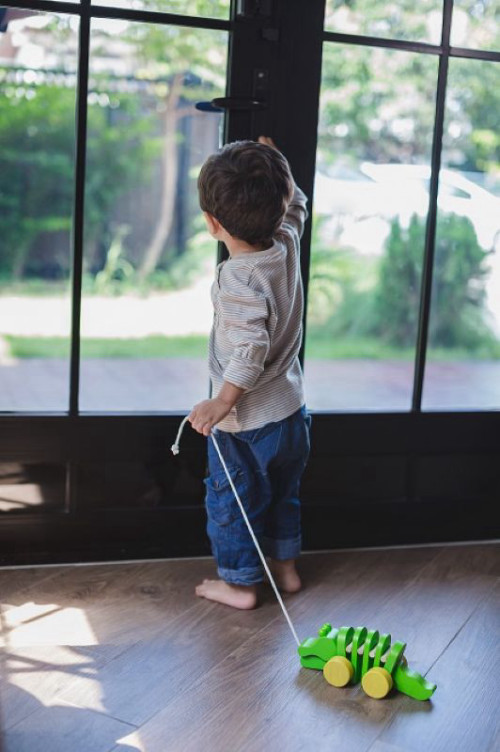 פעוט גורר תנין נגרר מעץ של PlanToys (הדגם הקלאסי הירוק) לעידוד הליכה